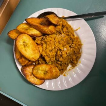 A picture showing freshly cooked yellow beans and fried plantain in a white plate